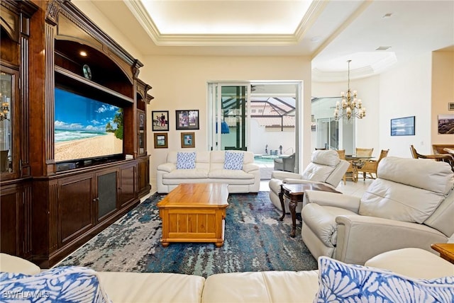 living area featuring ornamental molding, a chandelier, and a raised ceiling