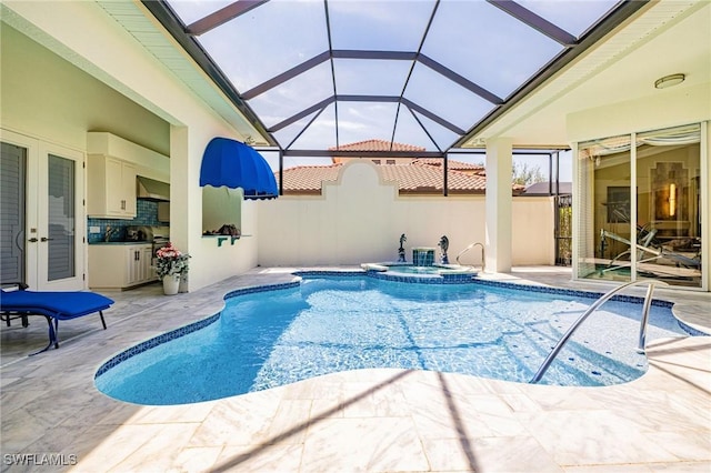 view of swimming pool with a patio area, a pool with connected hot tub, and a lanai