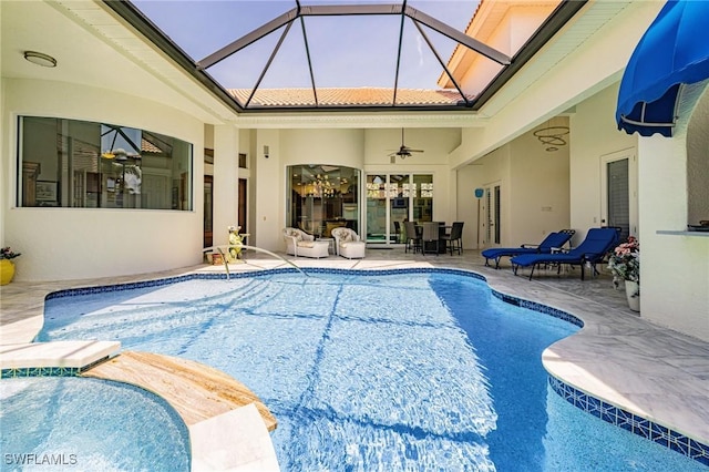outdoor pool with a patio area, ceiling fan, and outdoor dining space