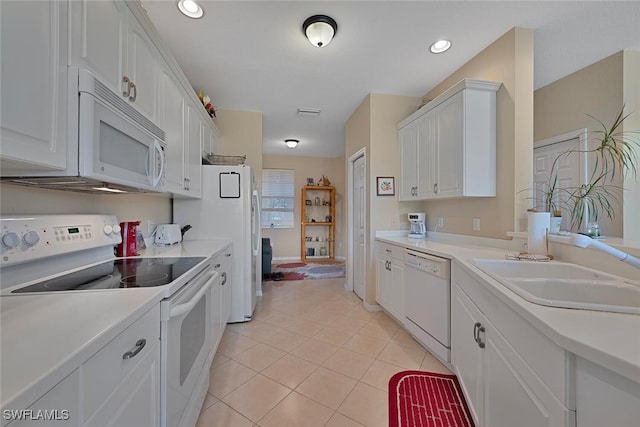kitchen featuring white appliances, a sink, white cabinets, light tile patterned flooring, and light countertops