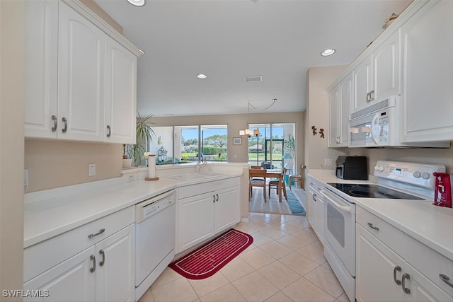 kitchen with white appliances, a sink, white cabinetry, recessed lighting, and light countertops