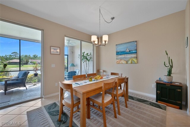 dining area with light tile patterned flooring, a chandelier, and baseboards