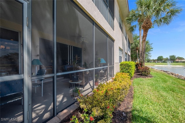view of side of home featuring a water view and a lawn