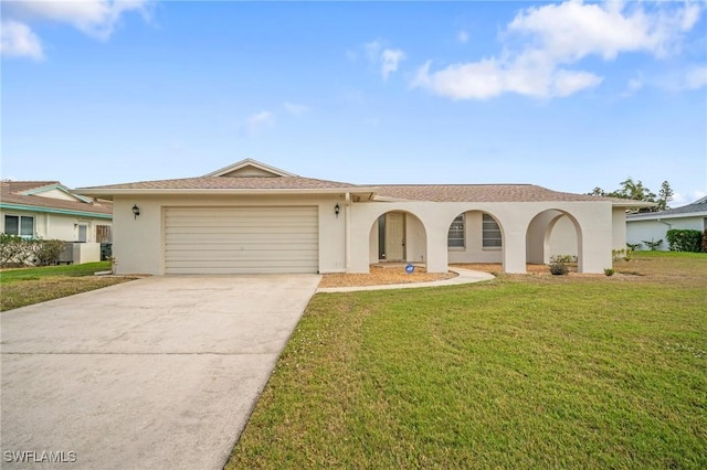 view of front of home with stucco siding, an attached garage, driveway, and a front yard