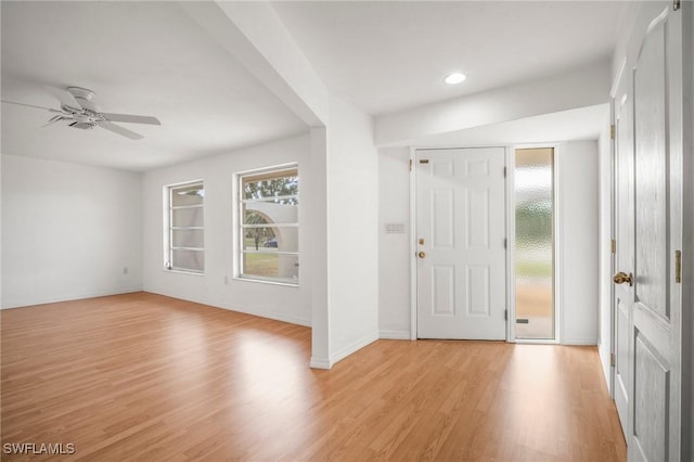 entrance foyer with baseboards, ceiling fan, a wealth of natural light, and light wood-style floors