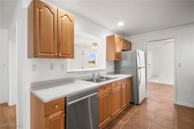 kitchen featuring light countertops, a sink, freestanding refrigerator, and dishwasher