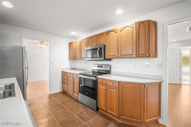 kitchen featuring appliances with stainless steel finishes, a sink, light countertops, dark tile patterned floors, and visible vents