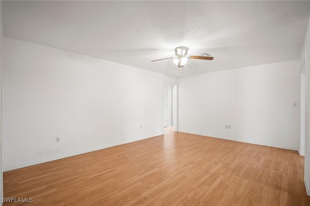empty room with baseboards, ceiling fan, and light wood-style flooring