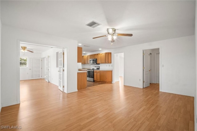 unfurnished living room featuring baseboards, a ceiling fan, light wood-style flooring, and visible vents