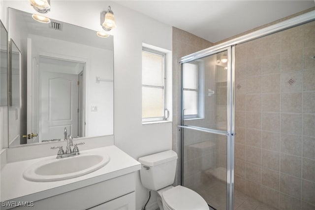 full bath with vanity, toilet, visible vents, and a stall shower
