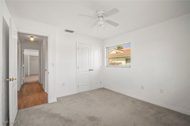 unfurnished bedroom with baseboards, visible vents, carpet, and a closet