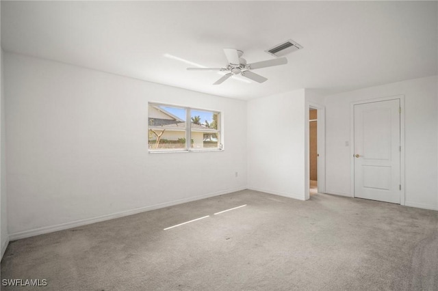 empty room with baseboards, carpet, a ceiling fan, and visible vents