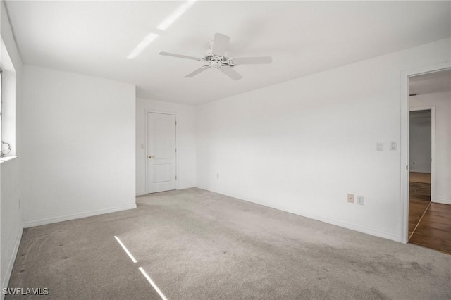 empty room with baseboards, ceiling fan, and carpet flooring