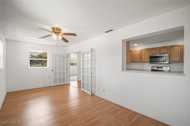 unfurnished room featuring ceiling fan, french doors, baseboards, light wood-type flooring, and visible vents
