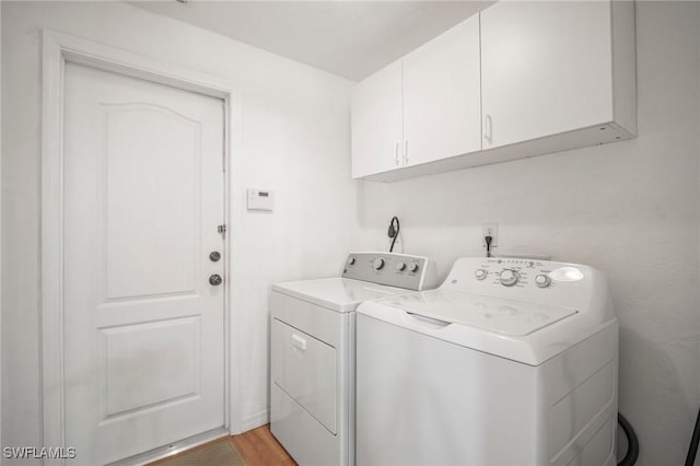 laundry area with light wood-style flooring, cabinet space, and washing machine and dryer