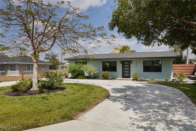 27551 Pullen Ave, Bonita Springs, FL 34135 - ranch-style house featuring stucco siding, a front lawn, fence, and curved driveway