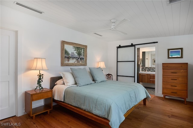 27551 Pullen Ave, Bonita Springs, FL 34135 - bedroom with wood finished floors, visible vents, and a barn door