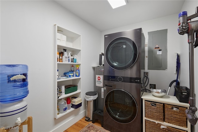 27551 Pullen Ave, Bonita Springs, FL 34135 - laundry area featuring electric panel, electric water heater, wood finished floors, stacked washer and clothes dryer, and laundry area