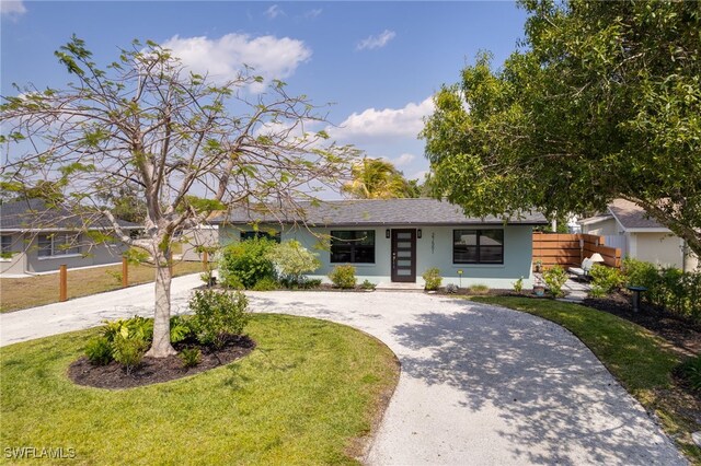 27551 Pullen Ave, Bonita Springs, FL 34135 - ranch-style house with stucco siding, fence, a front yard, and curved driveway