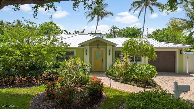 1135 7th St S, Naples, FL 34102 - bungalow-style home with a standing seam roof, an attached garage, decorative driveway, and a metal roof