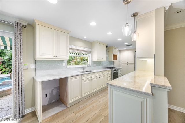 1135 7th St S, Naples, FL 34102 - kitchen with gas stove, tasteful backsplash, light stone counters, a peninsula, and wood tiled floors