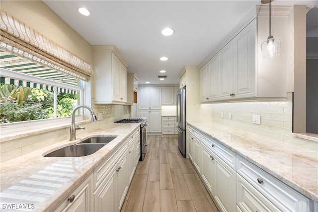 1135 7th St S, Naples, FL 34102 - kitchen featuring stainless steel appliances, light stone countertops, light wood-style flooring, recessed lighting, and white cabinetry