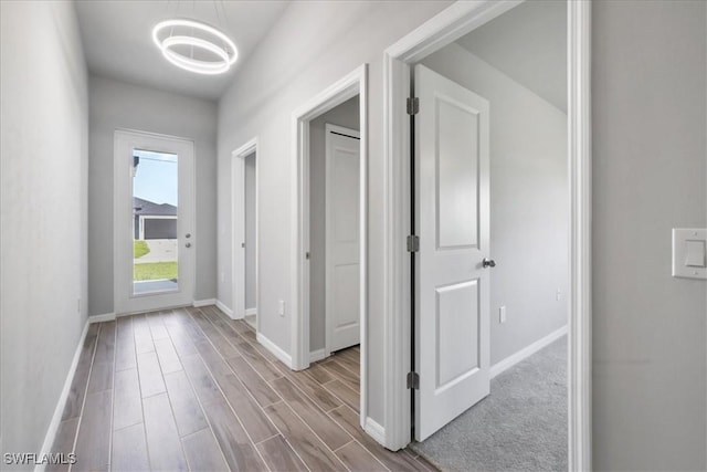 3225 58th St W, Lehigh Acres, FL 33971 - hall featuring an inviting chandelier, baseboards, and wood finished floors