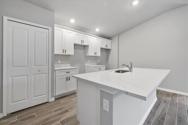 3225 58th St W, Lehigh Acres, FL 33971 - kitchen featuring a kitchen island with sink, white cabinetry, wood finish floors, and a sink