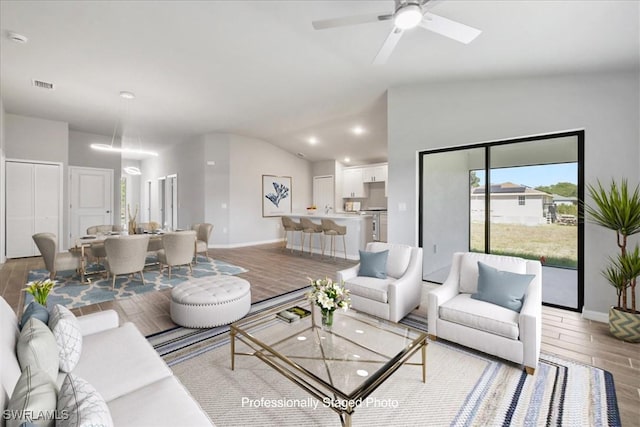 3225 58th St W, Lehigh Acres, FL 33971 - living area with lofted ceiling, baseboards, light wood-type flooring, and visible vents