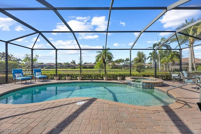 view of pool featuring a patio, a pool with connected hot tub, and glass enclosure