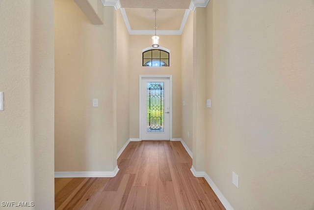 entryway featuring crown molding, light wood-style flooring, and baseboards