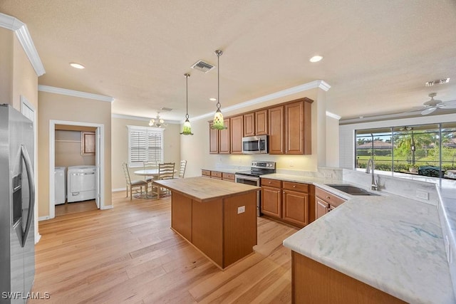 kitchen featuring stainless steel appliances, separate washer and dryer, crown molding, a sink, and wooden counters