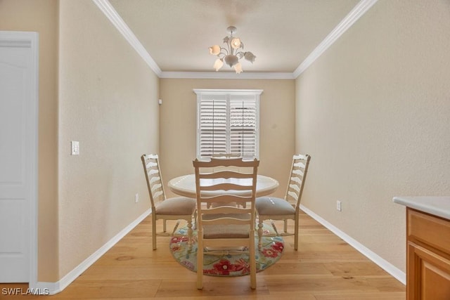 dining room with light wood-style floors, ornamental molding, a chandelier, and baseboards
