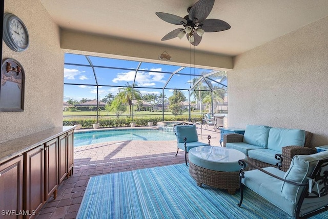 deck with a patio, an outdoor living space, a pool with connected hot tub, ceiling fan, and glass enclosure