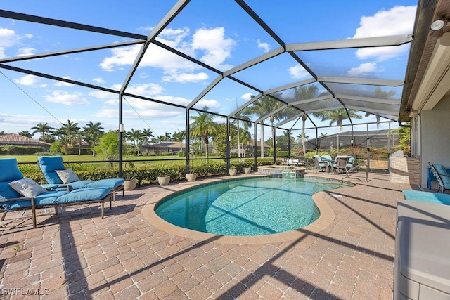 view of pool featuring a patio area, a pool with connected hot tub, and glass enclosure