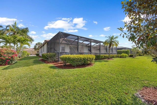 view of grassy yard featuring glass enclosure