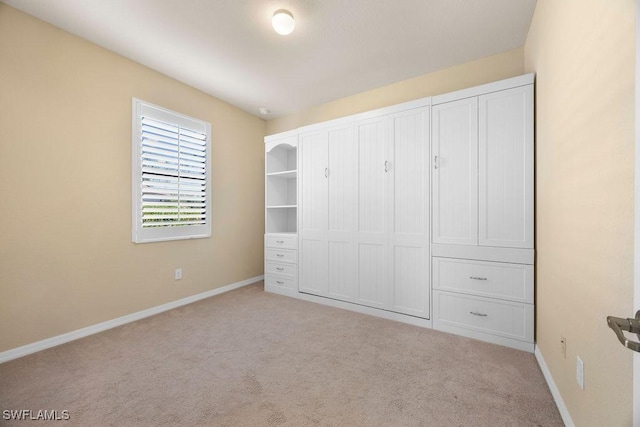 unfurnished bedroom with carpet floors and baseboards