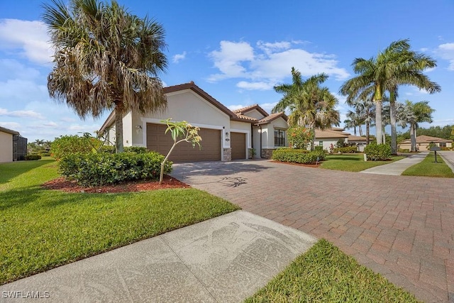 mediterranean / spanish home featuring an attached garage, decorative driveway, a front lawn, stucco siding, and a tile roof