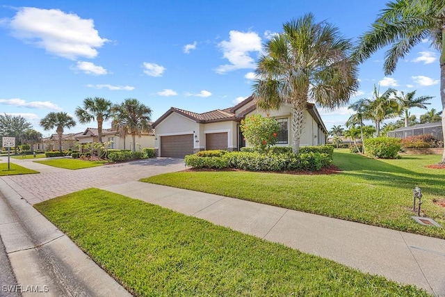 view of front of house featuring decorative driveway, stucco siding, a garage, a front yard, and a tiled roof