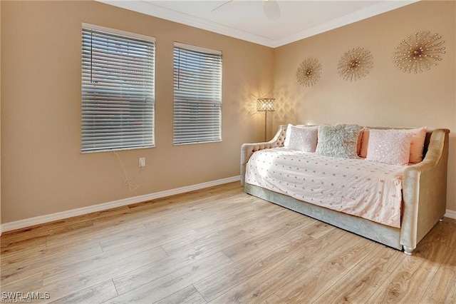 bedroom with a ceiling fan, baseboards, crown molding, and wood finished floors