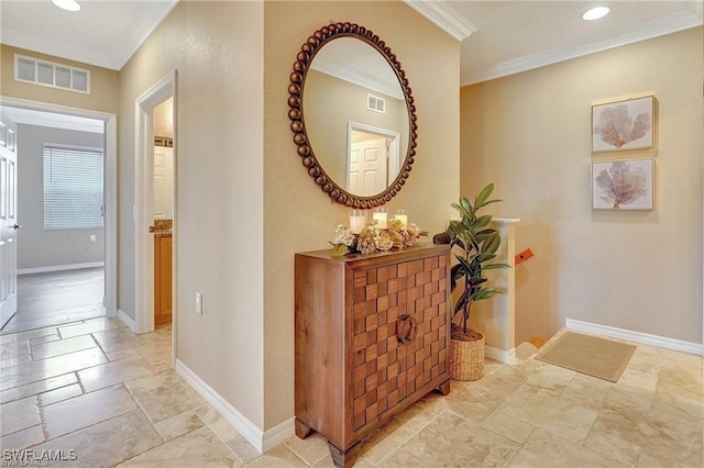 hallway with stone tile floors, visible vents, and ornamental molding