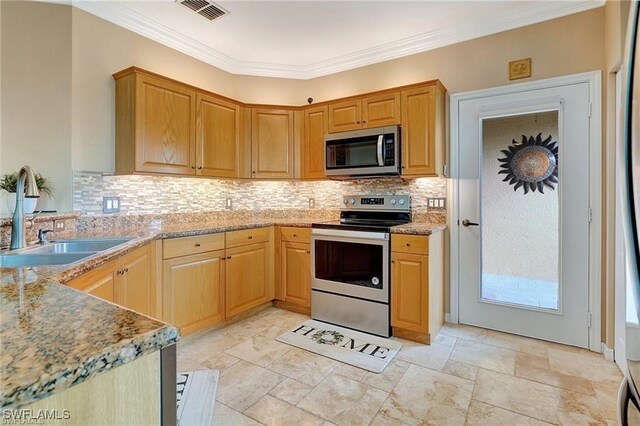 kitchen featuring backsplash, visible vents, a sink, crown molding, and appliances with stainless steel finishes