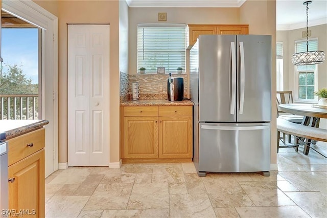 kitchen with stone tile floors, ornamental molding, freestanding refrigerator, baseboards, and tasteful backsplash
