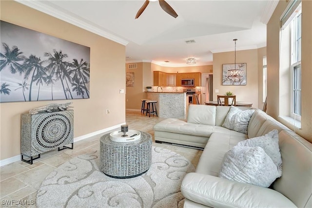 living room with a wealth of natural light, ornamental molding, ceiling fan, and visible vents