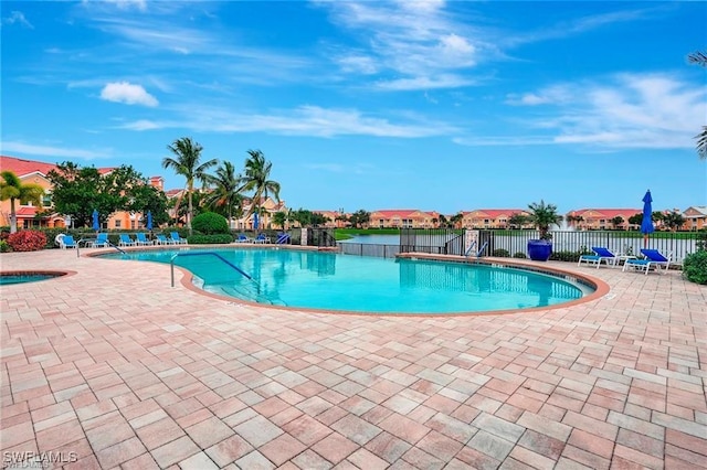 community pool with fence, a community hot tub, a residential view, and a patio