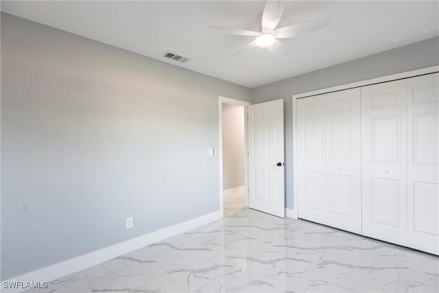 242 Ground Dove Cir, Lehigh Acres, FL 33936 - unfurnished bedroom featuring light marble finish floors, baseboards, a closet, and a ceiling fan