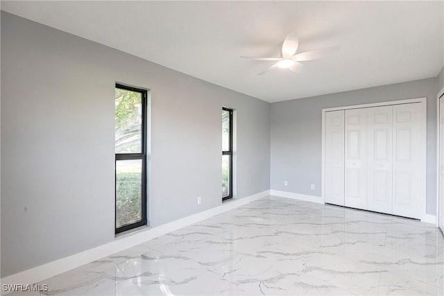 242 Ground Dove Cir, Lehigh Acres, FL 33936 - unfurnished bedroom with baseboards, marble tiled floors, multiple windows, and a closet