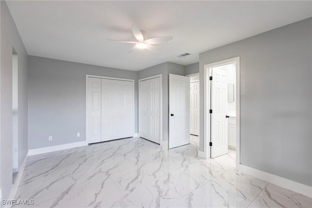 242 Ground Dove Cir, Lehigh Acres, FL 33936 - unfurnished bedroom with baseboards, light marble finish floors, two closets, connected bathroom, and a ceiling fan