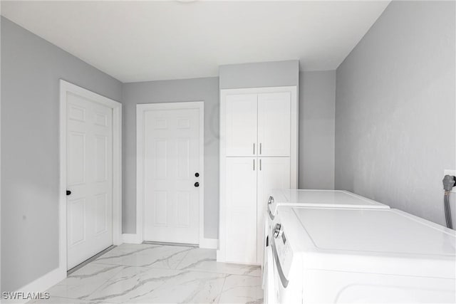 242 Ground Dove Cir, Lehigh Acres, FL 33936 - laundry room with cabinet space, washing machine and dryer, light marble finish floors, and baseboards