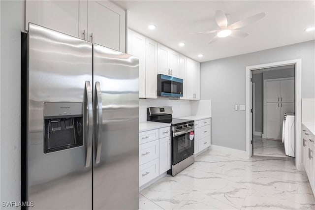 242 Ground Dove Cir, Lehigh Acres, FL 33936 - kitchen featuring appliances with stainless steel finishes, a ceiling fan, washing machine and dryer, baseboards, and white cabinetry